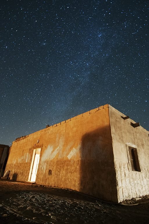 An adobe building under a starry sky