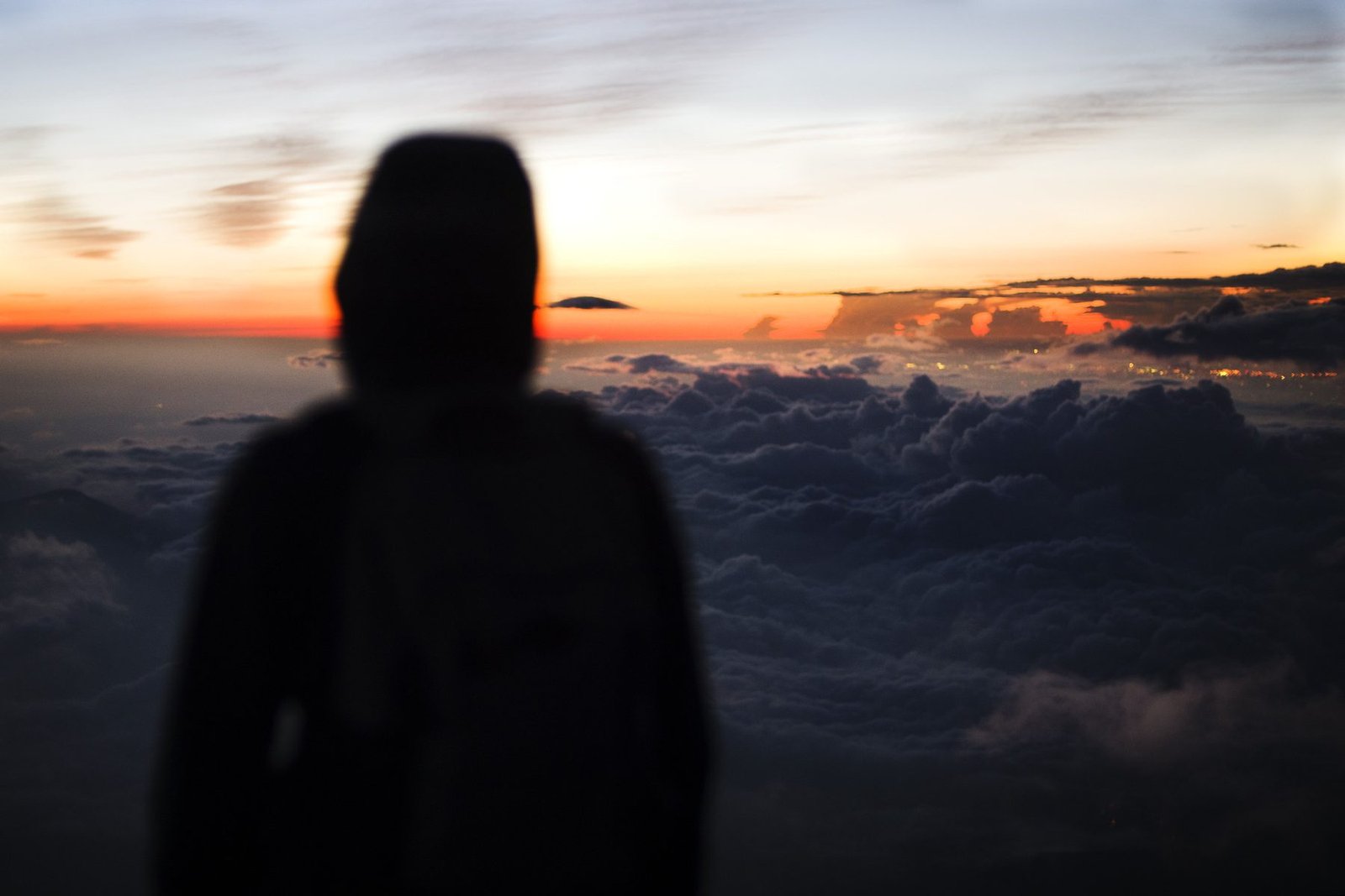 Silueta sobre un mar de nubes al amanecer